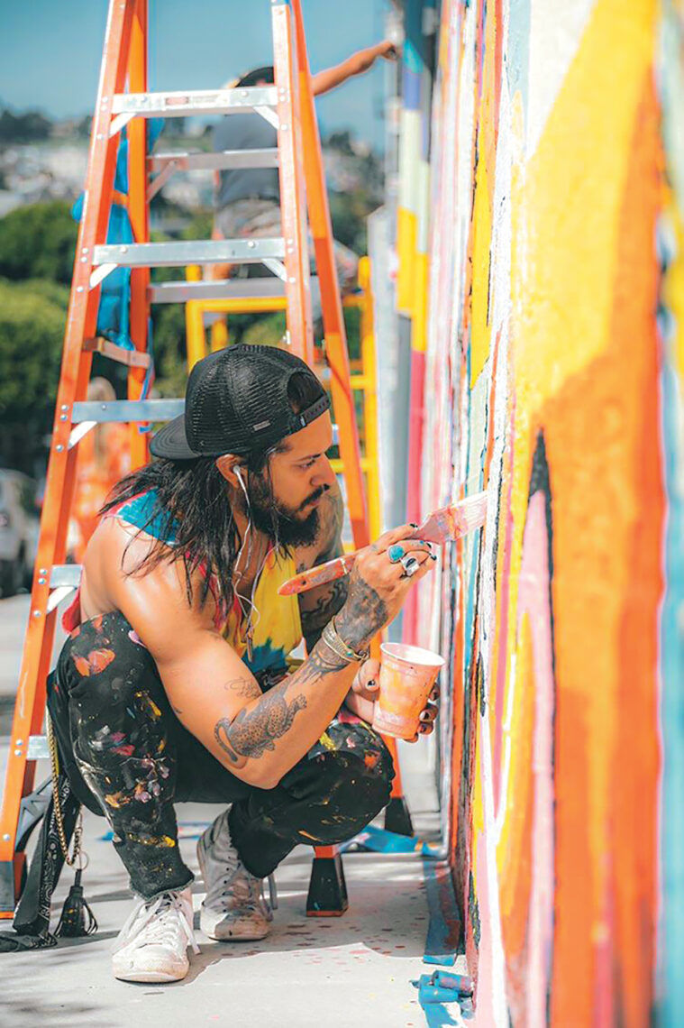 Brazilian-born artist Guilherme Lemes works on a mural.