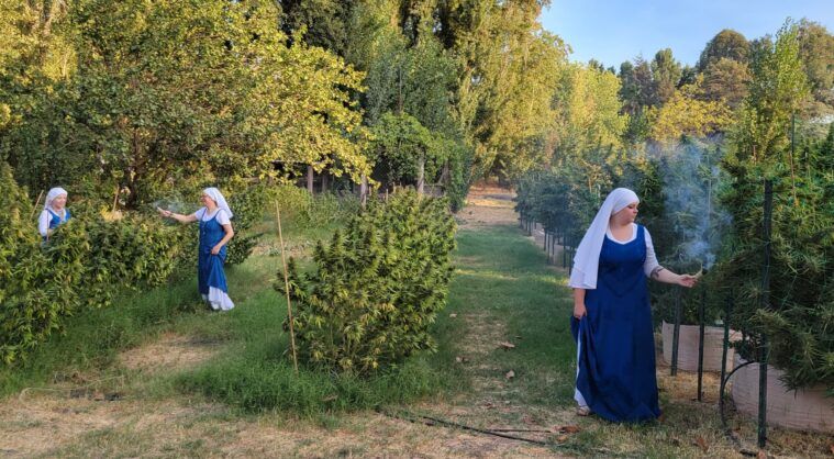 Sisters burn sage to cleanse growing plants.